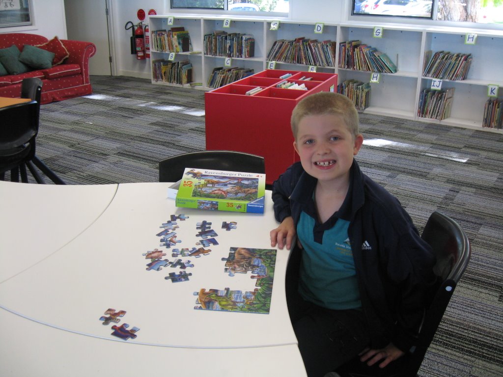 a school kid in library playing puzzle